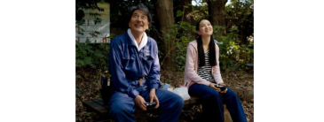 Man and girl sitting looking up at the sky and smiling