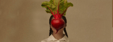 Girl with beetroot in front of her face