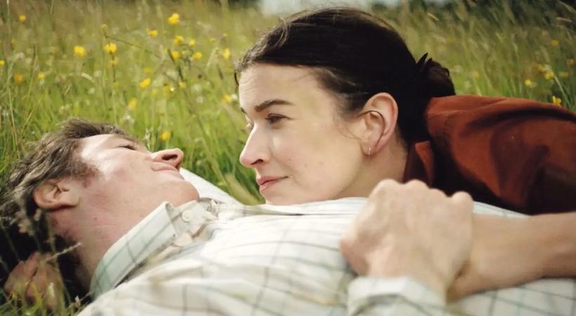 Man and woman embracing lying down.
